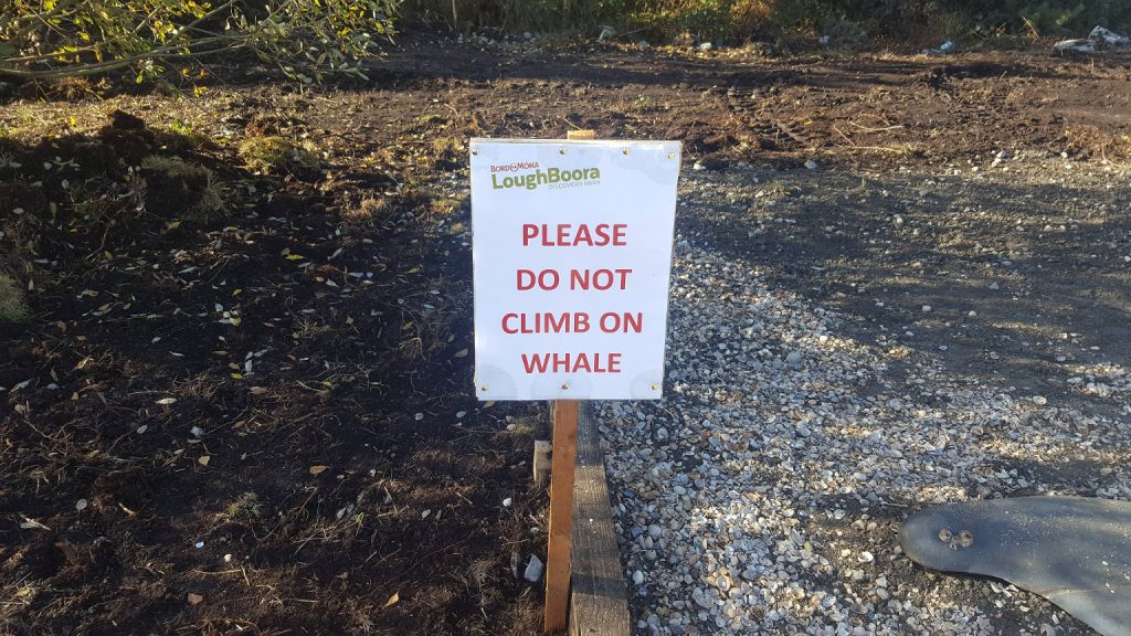 Sign saying "Please do not climb on the whale"
